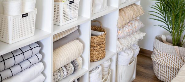 a white cube organizer filled with storage bins and other household items in an organized, neat way.