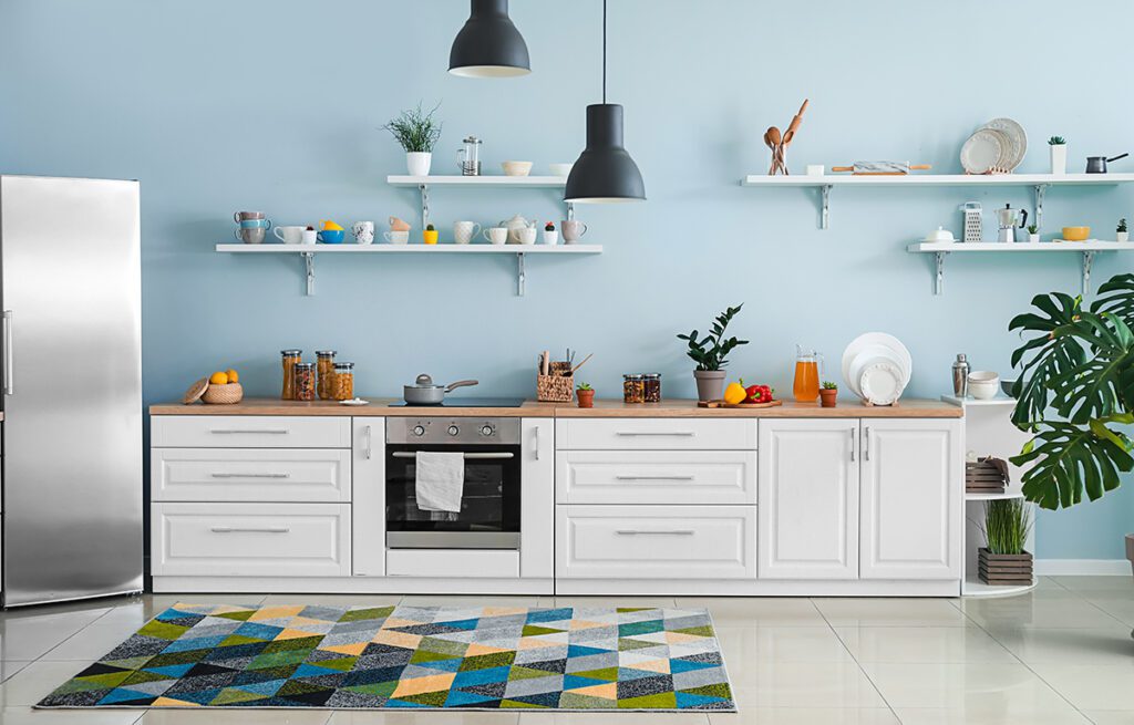 A simple kitchen with white lower cabinets and only simple shelves above the wooden countertop.